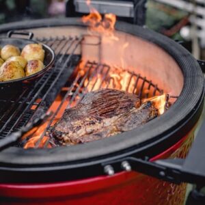 Transform your backyard cooking with the Kamado Joe KJ23RHC Classic II Smoker BBQ, featuring a cast iron cart, heat deflectors and ash tool. Enjoy smoky flavors with this versatile charcoal grill.